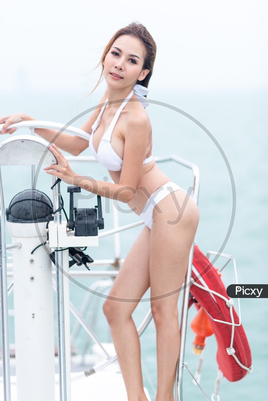 Image of Sexy Asian girl in white bikini on a yacht-WM675990-Picxy