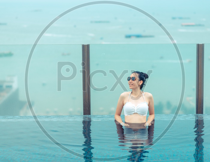 Outdoor Photoshoot of an Asian girl in Swimming pool on roof top with beautiful city view