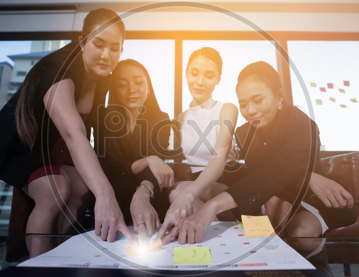 Group Of Young Business Women Discussing At Office Desk
