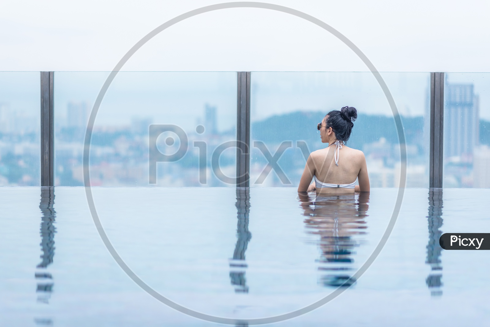 An Asian Swimming pool on roof top with beautiful city and sea view