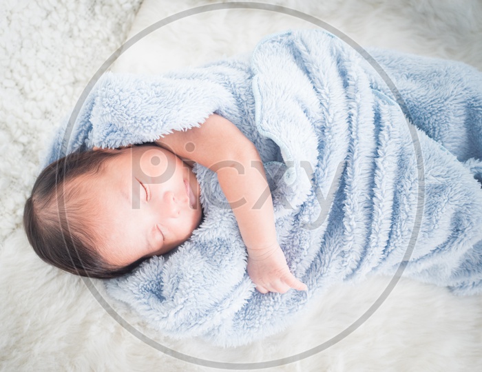 Infant baby in blue turkey towel