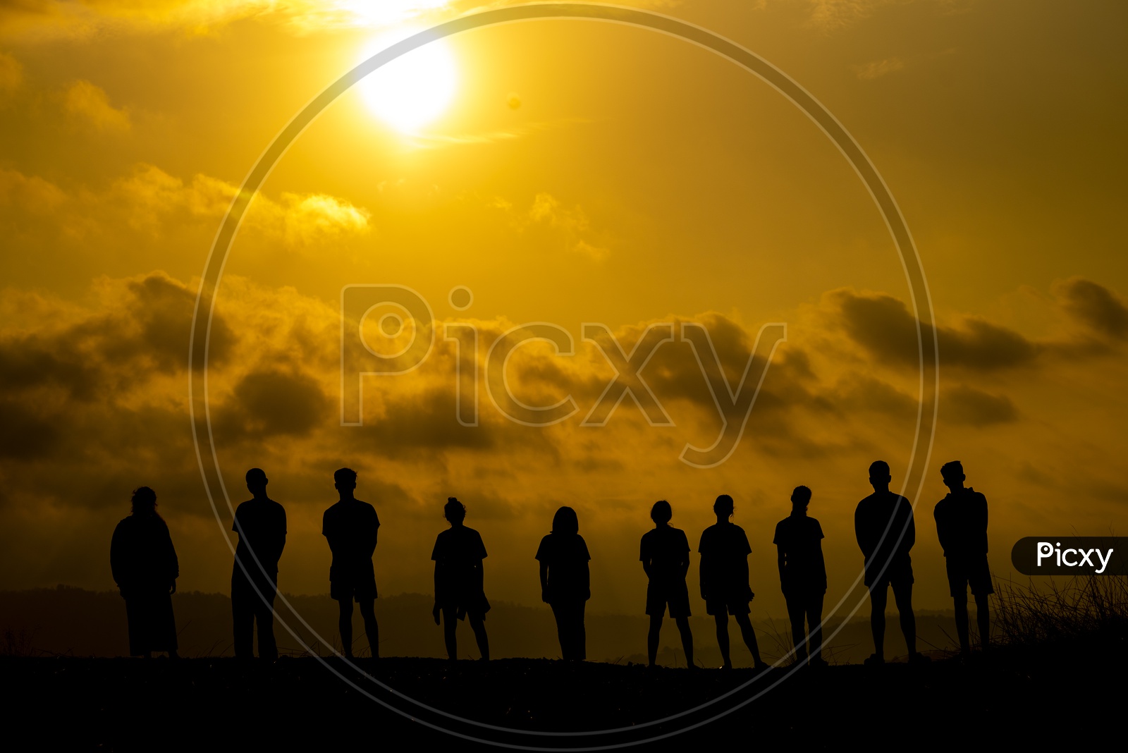 Group Of People Silhouette  on Hilltop Over Sunset Sky