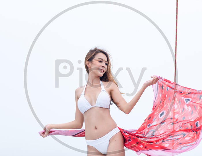Sexy Asian girl in white bikini with red scarf