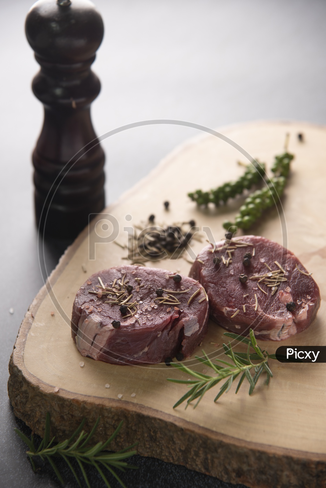 Spices Topped On Raw Beef Steaks On wooden Cutting Board