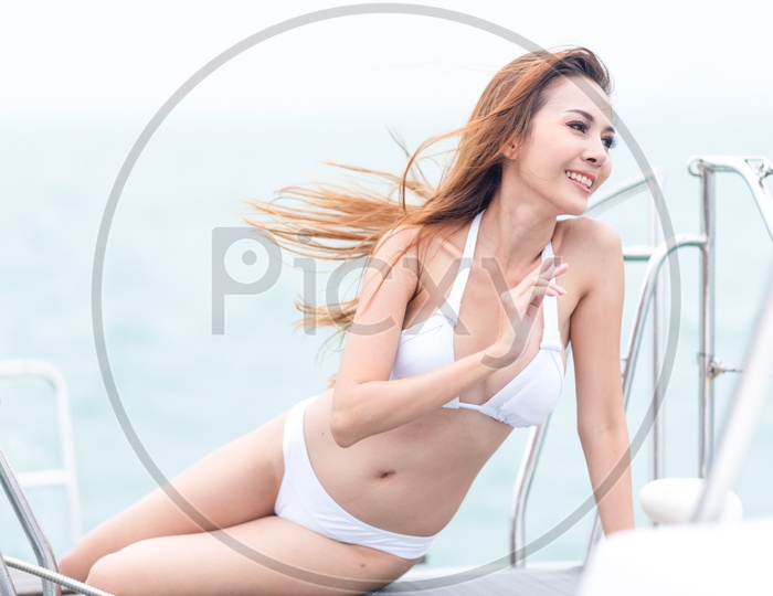 Sexy Asian model in bikini during a photo-shoot on a yacht