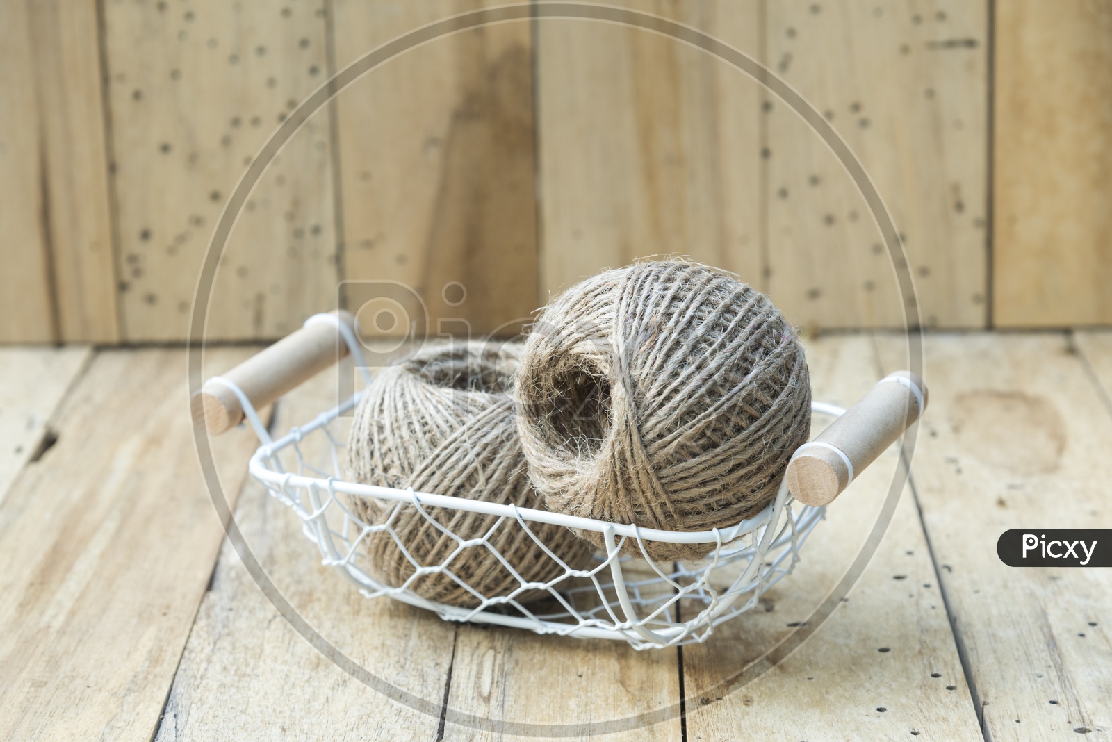 Basket With Vintage Rope Roll  Closeup Over Isolated Wooden Background