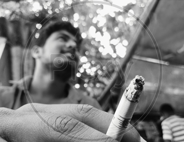 A boy holding cigarette in between his fingers