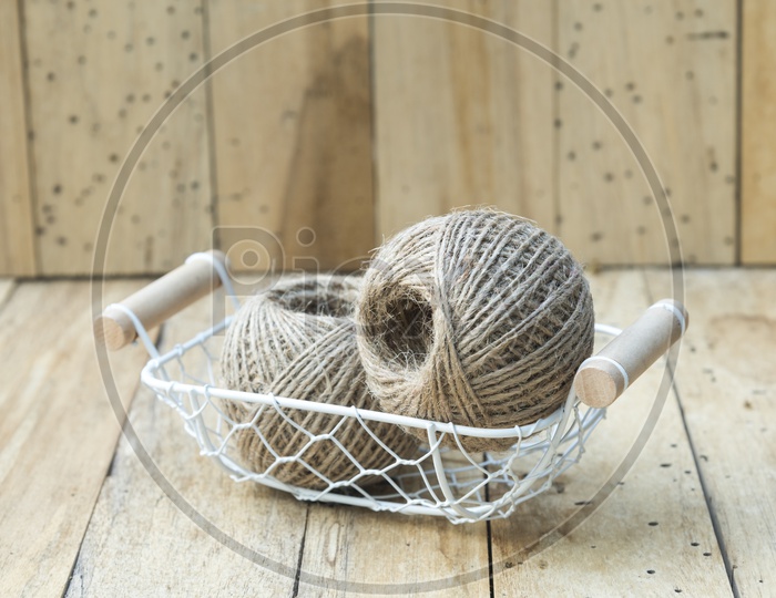 Basket With Vintage Rope Roll  Closeup Over Isolated Wooden Background