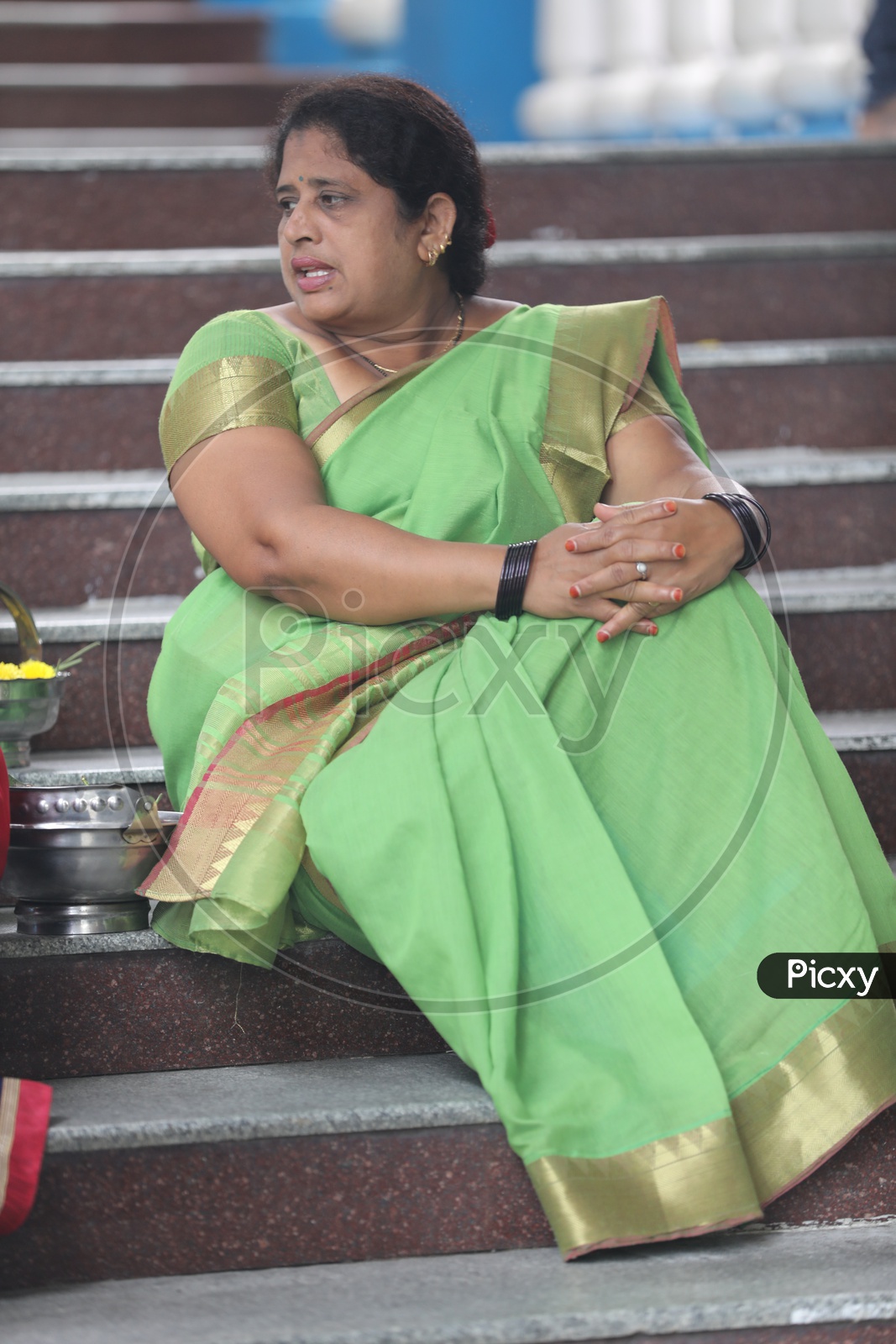 Indian woman wearing saree sitting on the steps
