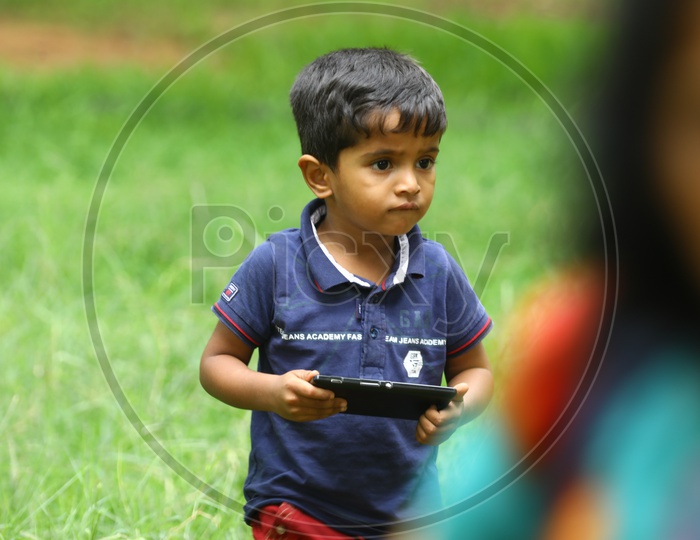A little boy holding a mobile phone