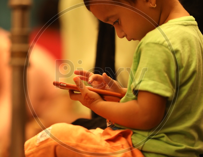 Indian Kid using Smartphone or Mobile