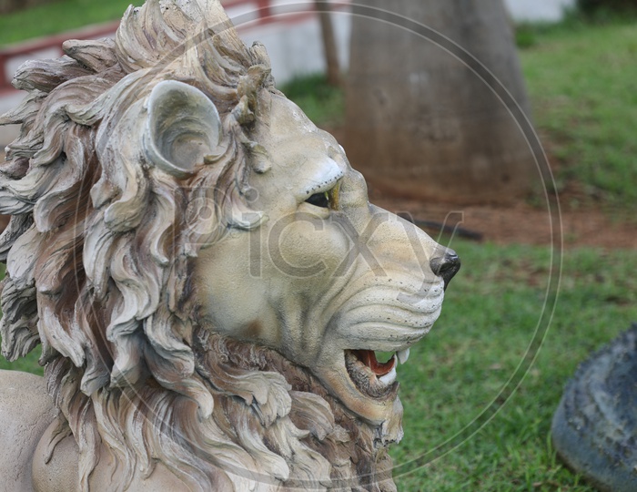 Lion Head With Fur Statue In a Lawn Garden