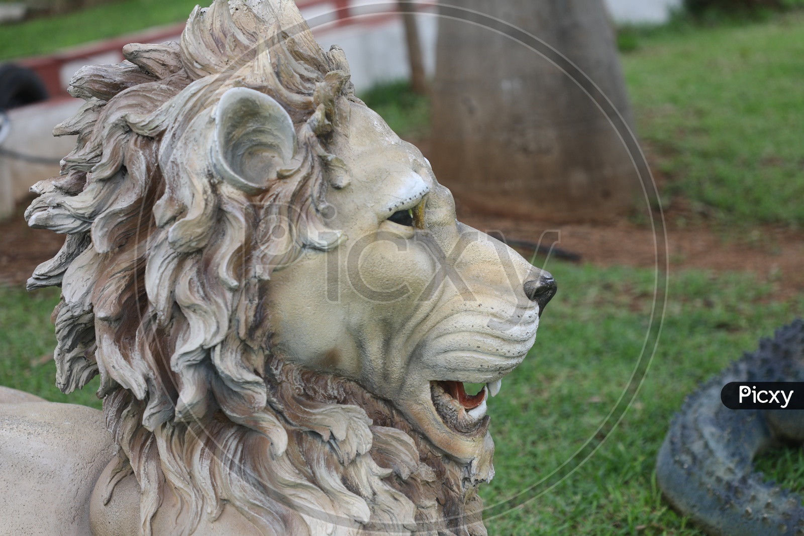 Lion Head With Fur Statue In a Lawn Garden