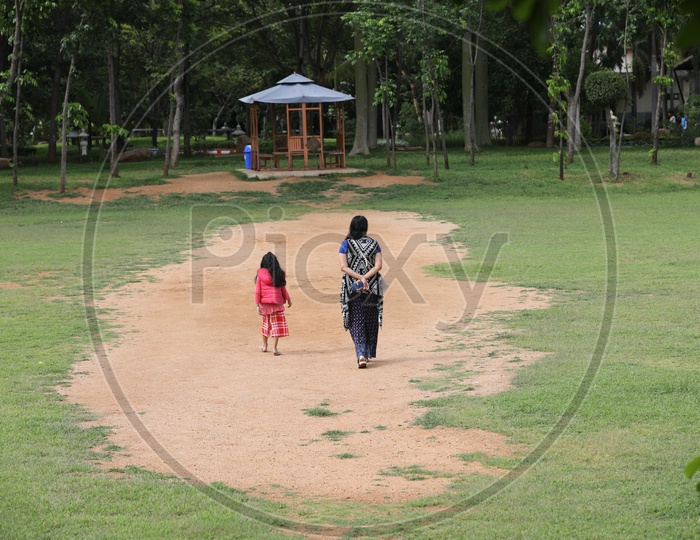 Indian Mother Walking with Her daughter in a Park