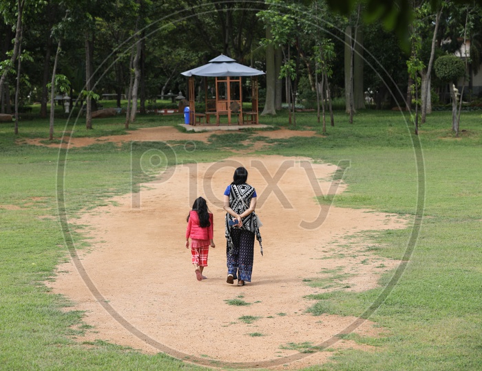 Young Indian Mother Walking with Her daughter in a Park