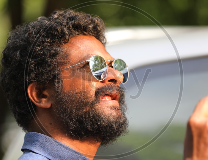 An Indian Man with facial hair wearing sunglasses