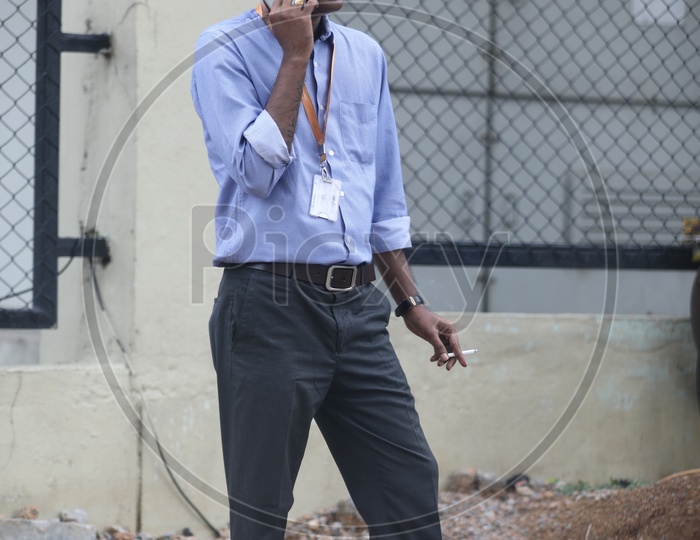IT Employee Smoking Cigarette While Speaking in Mobile Phone