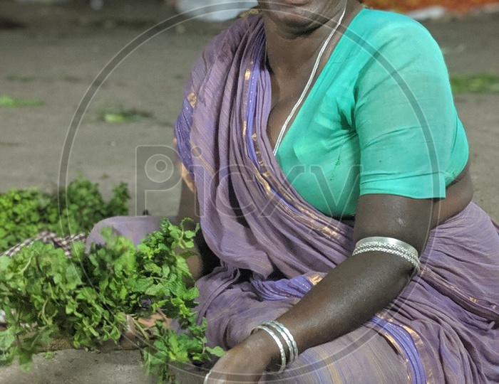 A happy and old granny selling vegetables in one of hyderabad's vegetable markets.