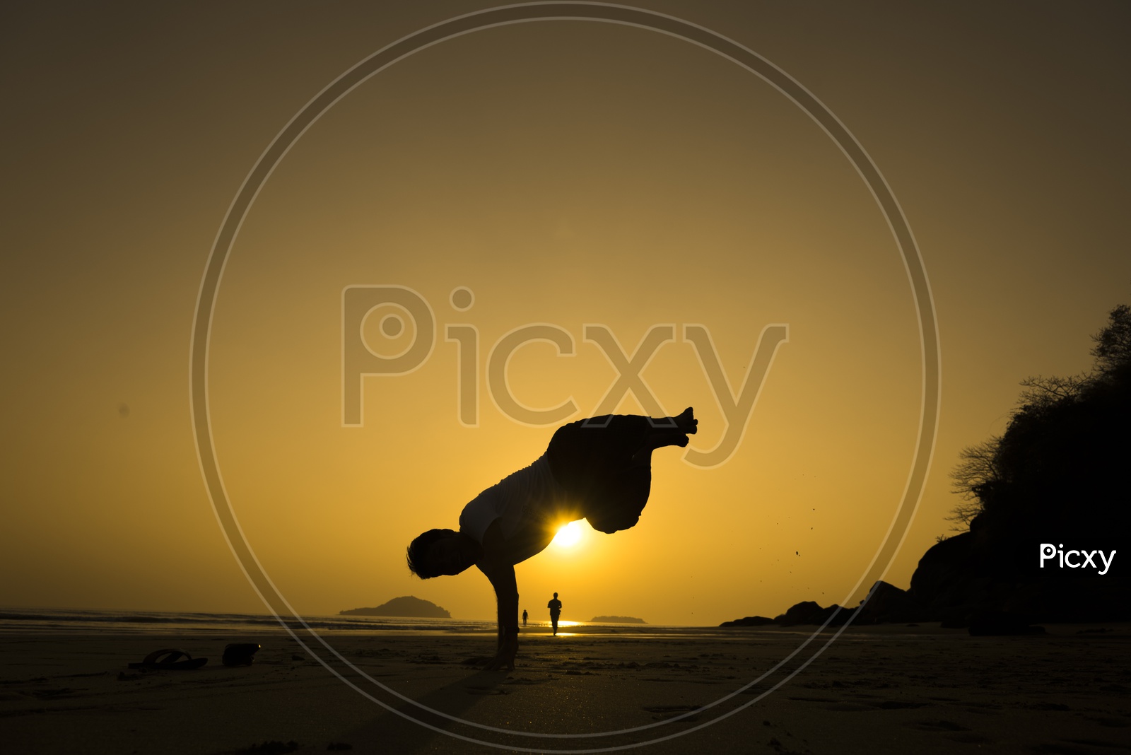 Silhouette of a man freestyle dancing at the beach during sunset in Thailand