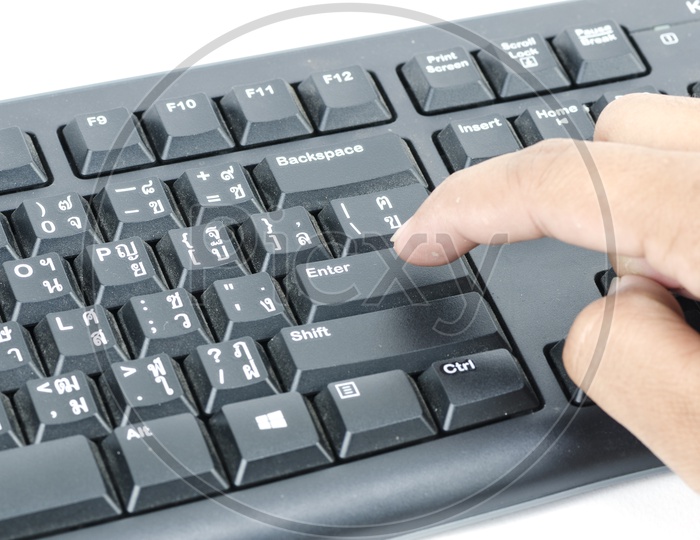 Young Man Finger Pressing Enter Button in a Keyboard