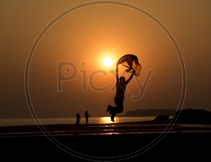silhouette of a jumping with scarf during Thailand sunset