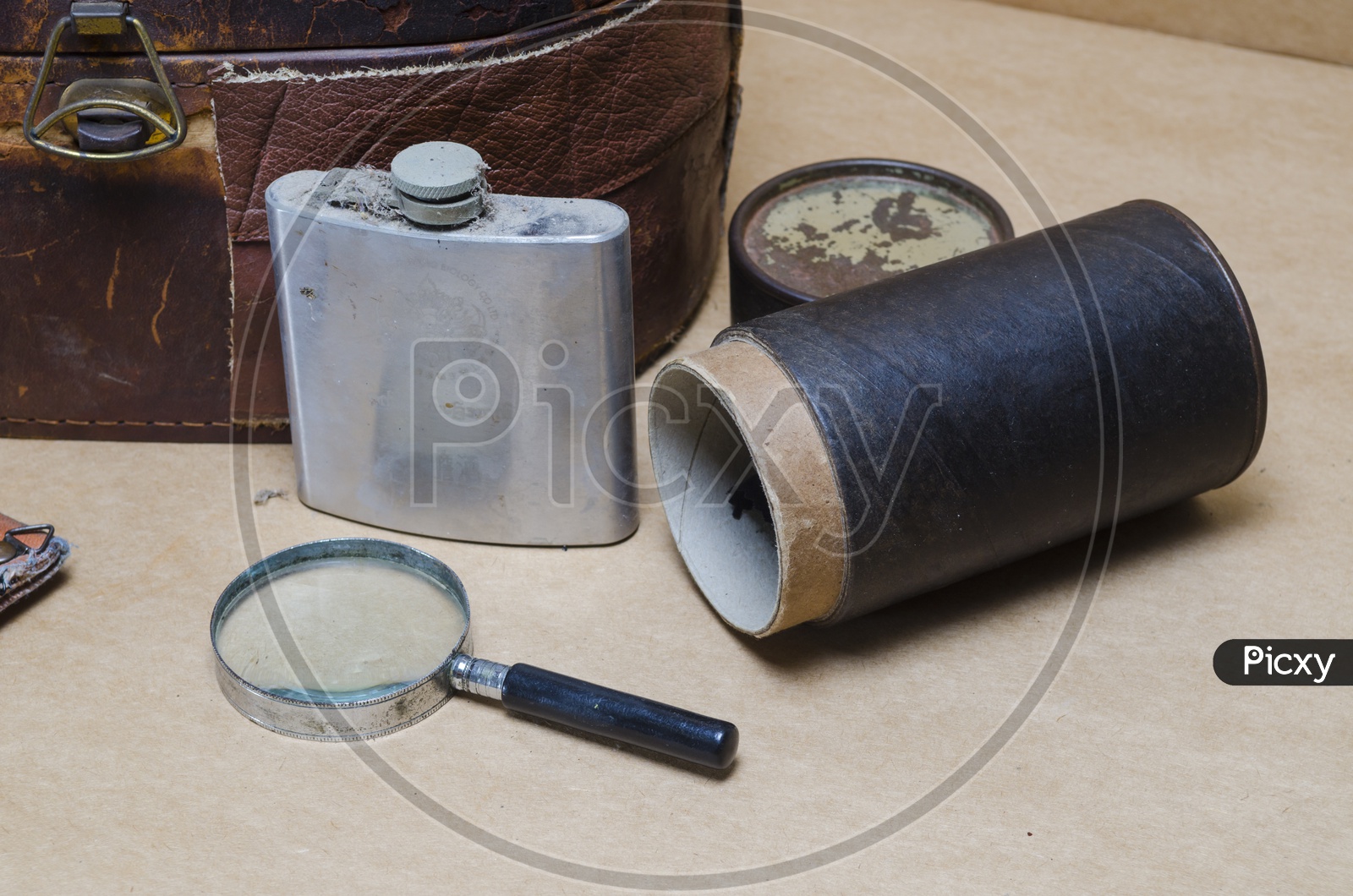 Magnifying Glass and Hip Flask Bottle on Wooden Background