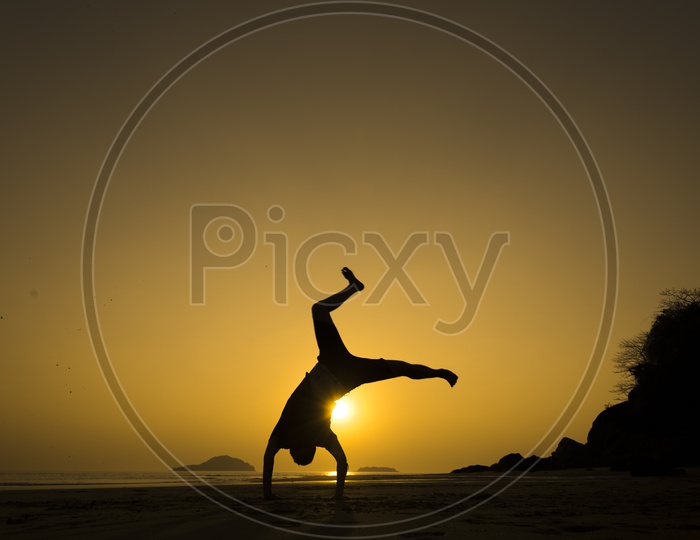 Silhouette of a man doing jump flip during sunset in Thailand