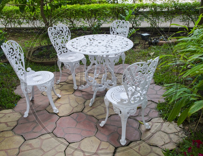 White table and chairs alongside the garden in Thailand