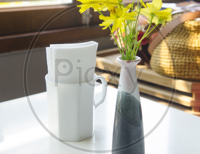 Cooling Glass on Table with Flower vase in Background