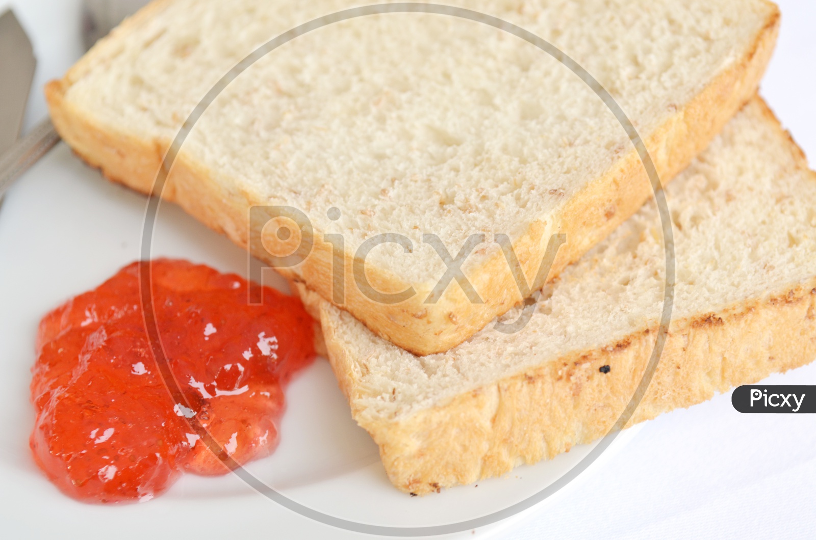 A good piece of toast with  Strawberry  Jam and Butter