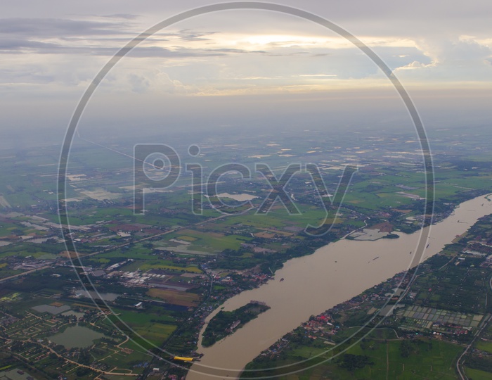 Aerial View Of Green Agricultural Fields And Village Scape From Flight Window