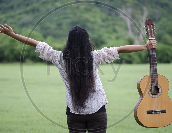 Woman with guitar Enjoying In Nature