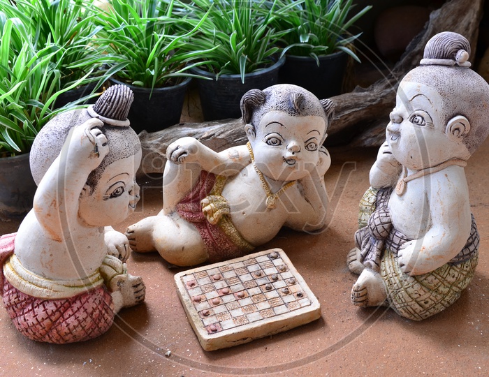 Statue Of Thai Boys Playing Chess In  A Hotel Garden