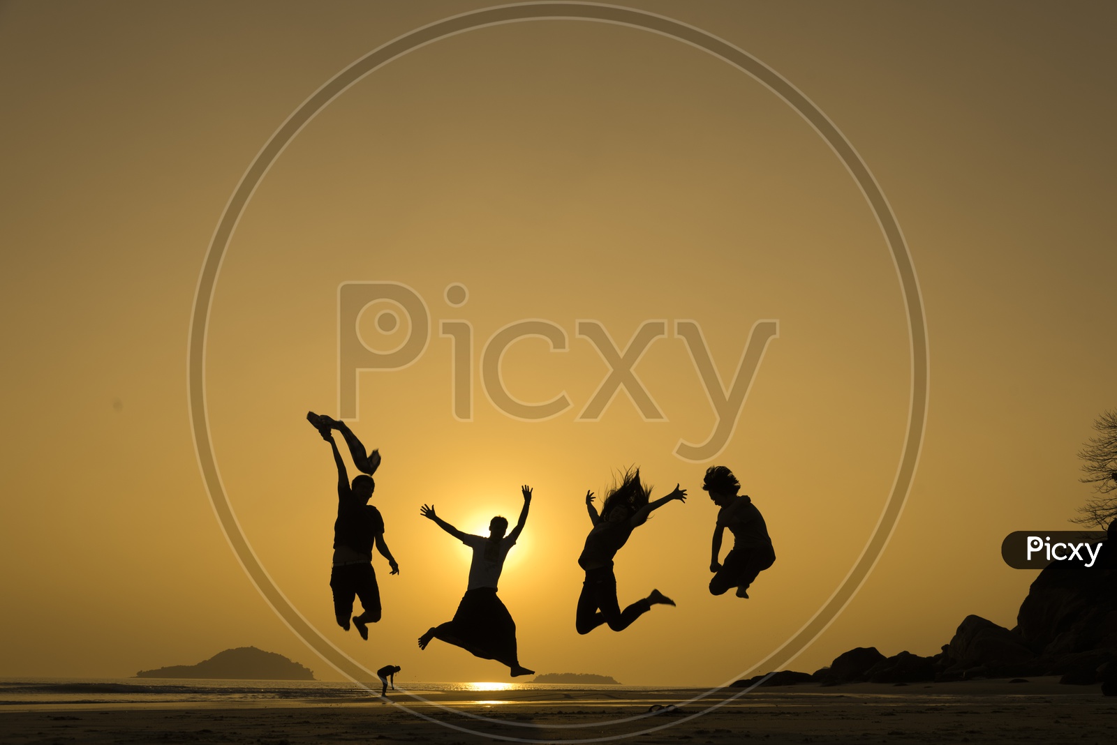 Silhouette of Group of young people jumping with joy at the beach during sunset in Thailand