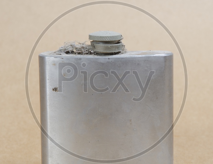 Old Stainless Steel Hip Flask bottle on vintage paper background