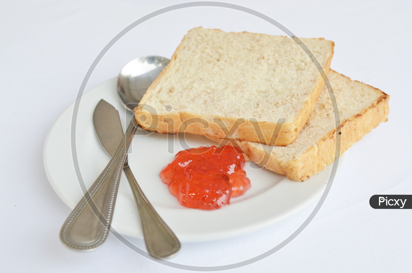 A good piece of toast with  Strawberry  Jam and Butter  Served in a Plate