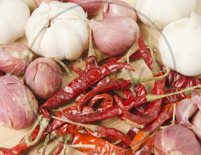 Red Chilies, Onions and Garlic on wooden background