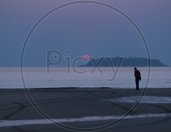 A Lonely man by the Thailand beach during sunset