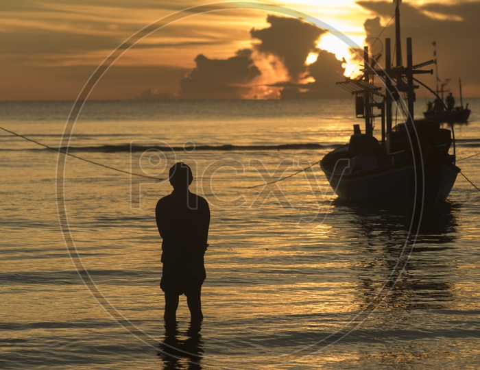 A Thailand Fisherman with his boat during sunset