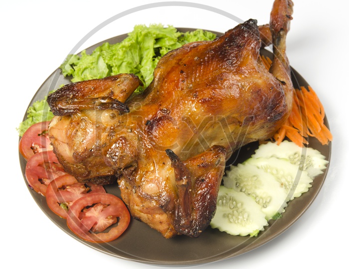 whole grilled chicken garnished with vegetables in plate
