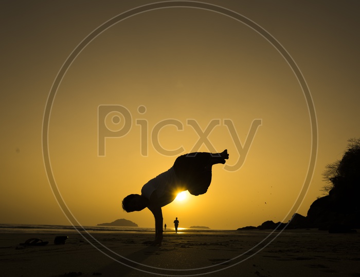 Silhouette of a man freestyle dancing at the beach during sunset in Thailand