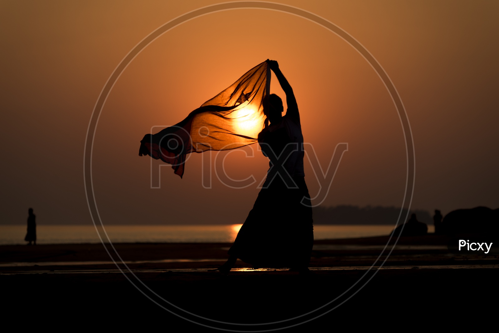 Silhouette of a man playing with scarf during sunset in Thailand