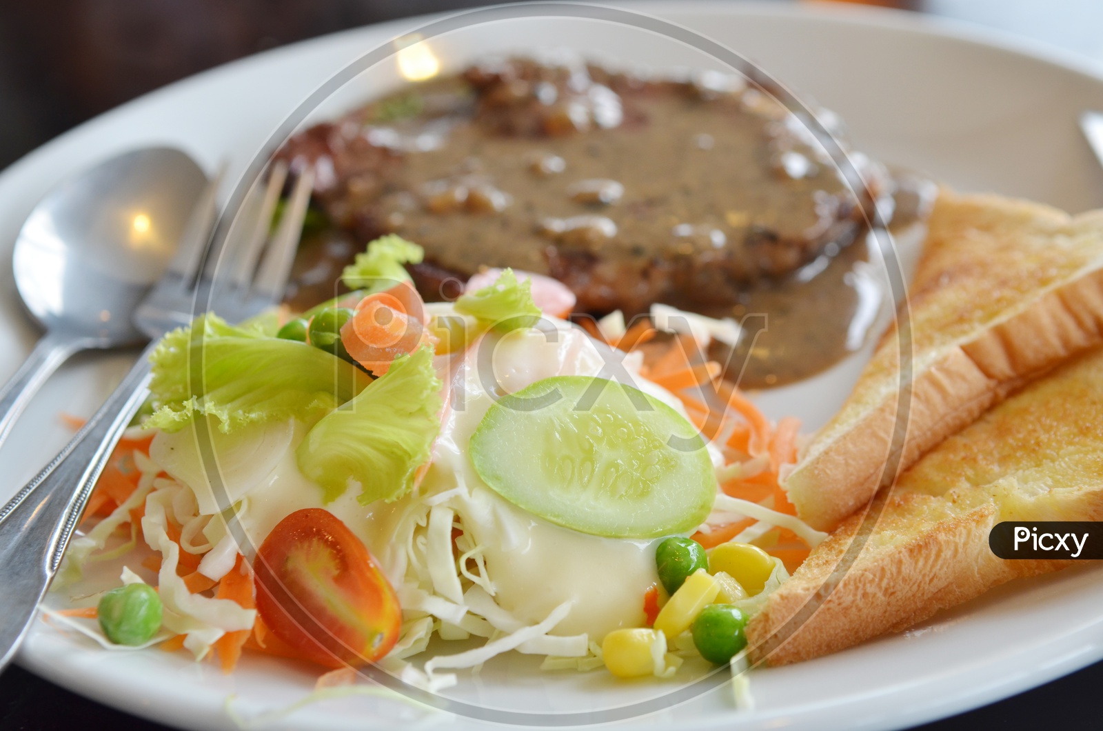 Grilled Beaf Steak Served With Fresh Salad  And Toasted Bread Slices