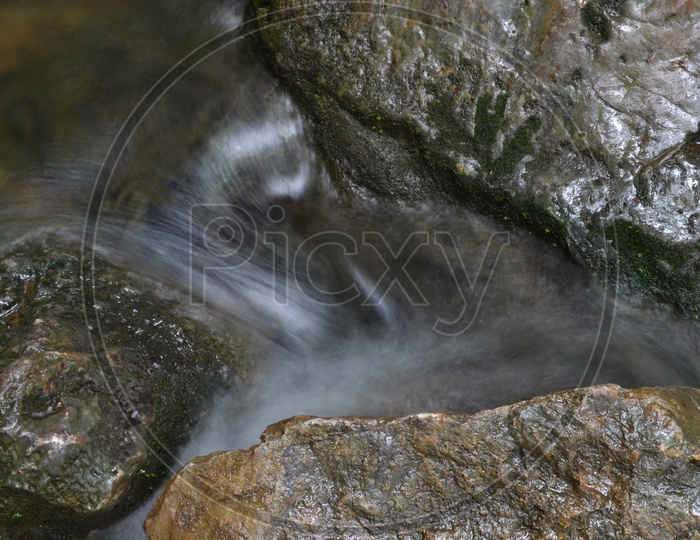 Stream flowing With Smooth Silky Texture Flow Over Rocks