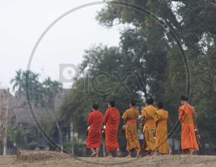 Traditional Alms buddhist monks on the streets of Luang Prabang, Laos