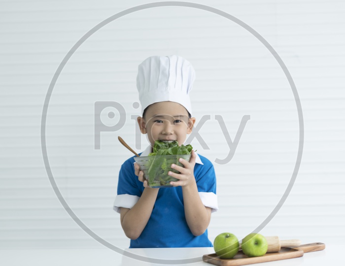 Asian young chef eating leafy vegetables