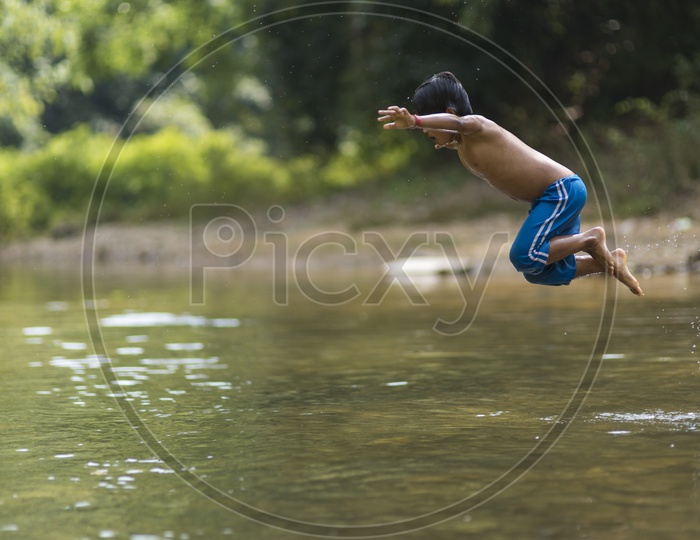 A Burmese boy child diving in a river.