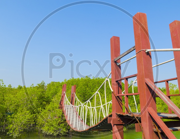 Red Wooden Suspended Bridge Over Krabi River In Mangrove Forest