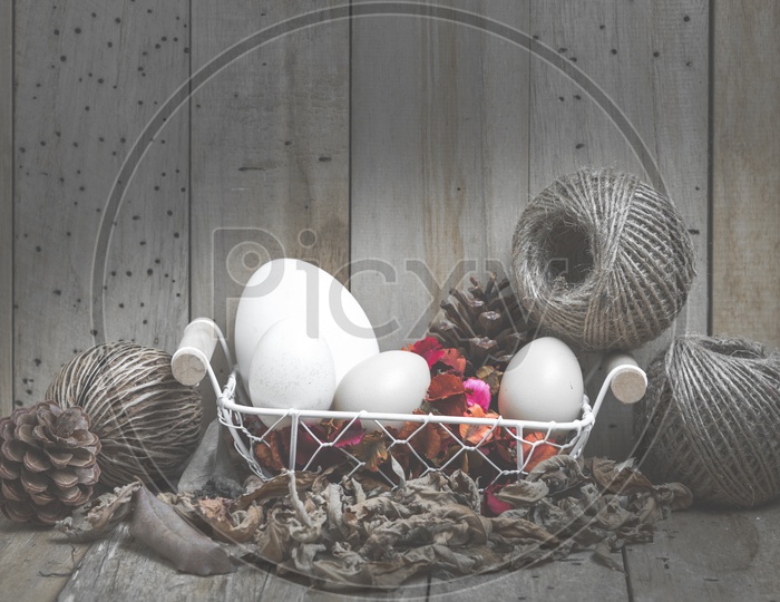 easter eggs in a basket with wood background, vintage filtered Images