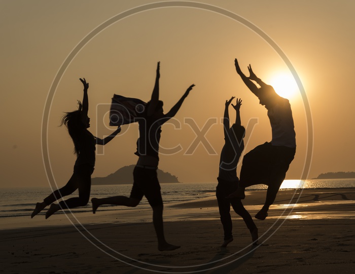 Silhouette pf  young people dancing and spraying at the beach in Thailand